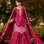 Magenta Pink Embroidered Crepe Gharara Set: A woman in a vibrant pink festive outfit featuring silver Zari handwork, flared gharara pants, and a matching dupatta.