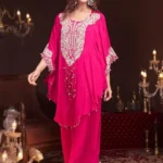 Vibrant Pink Chinon Palazzo Set with Silver Embroidery: A woman posing in a premium 3-piece ethnic ensemble featuring a short tunic with intricate silver handwork on the neckline and hem, paired with wide-leg palazzo trousers and a sheer dupatta.