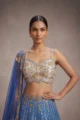 Designer blue lehenga choli for luxury wedding featuring intricate gold mirror work and a sheer dupatta.