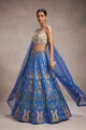 Close-up of a blue ethnic lehenga set with heavy sequin detailing and a floral gold embroidered sweetheart neckline choli.