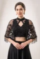 Close-up view of the dense handcrafted beadwork, glittering sequins, and keyhole neckline on the sheer net poncho cape.