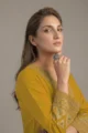 Detailed view of the heavy block thread embroidery on the wide sleeves of the mustard yellow rayon tunic shirt.