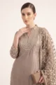 Detailed view of the scalloped cutout embroidery and hanging bead droplet fringes on the cuffs and hem.