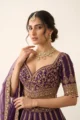 Close-up view of the dense gold zari embroidery, sweetheart neckline, and hanging bead fringe on the purple silk choli.