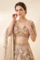 Close-up view of the dense multi-colored thread embroidery, V-neckline, and bead fringe on the off-white organza choli.